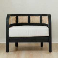 black and white caned club chair with retro vibes and a curved back