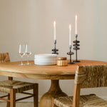 Cozy dining room scene with a natural round wooden table and seagrass and teak wood dining chairs