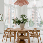 natural round dining table with dining chairs in a parisian style high ceiling dining room