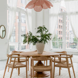 natural round dining table with dining chairs in a parisian style high ceiling dining room