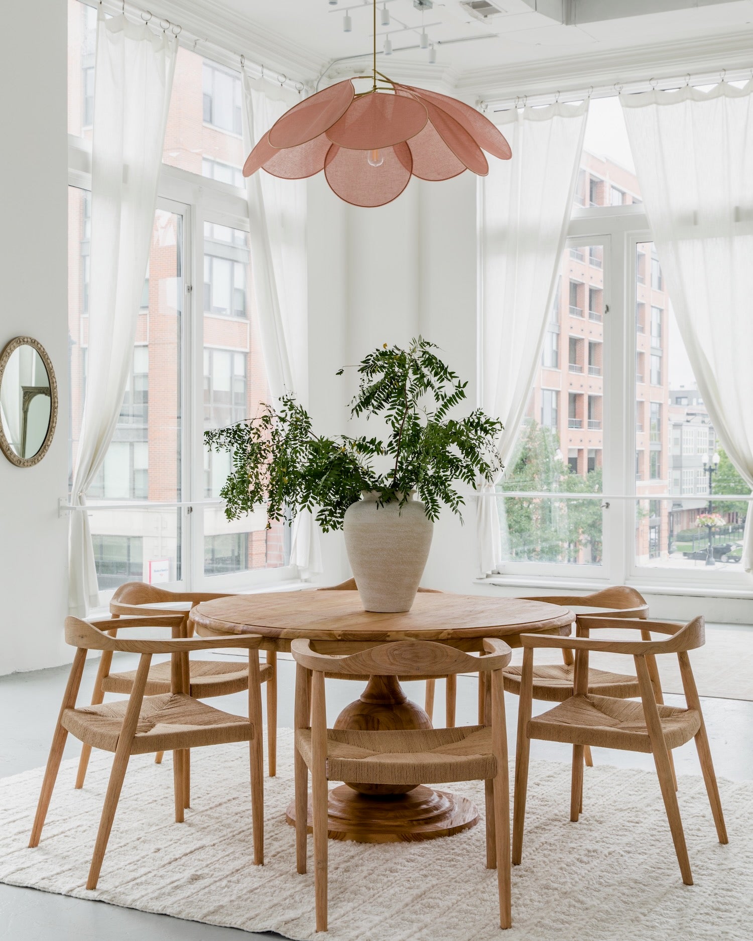 natural round dining table with dining chairs in a parisian style high ceiling dining room