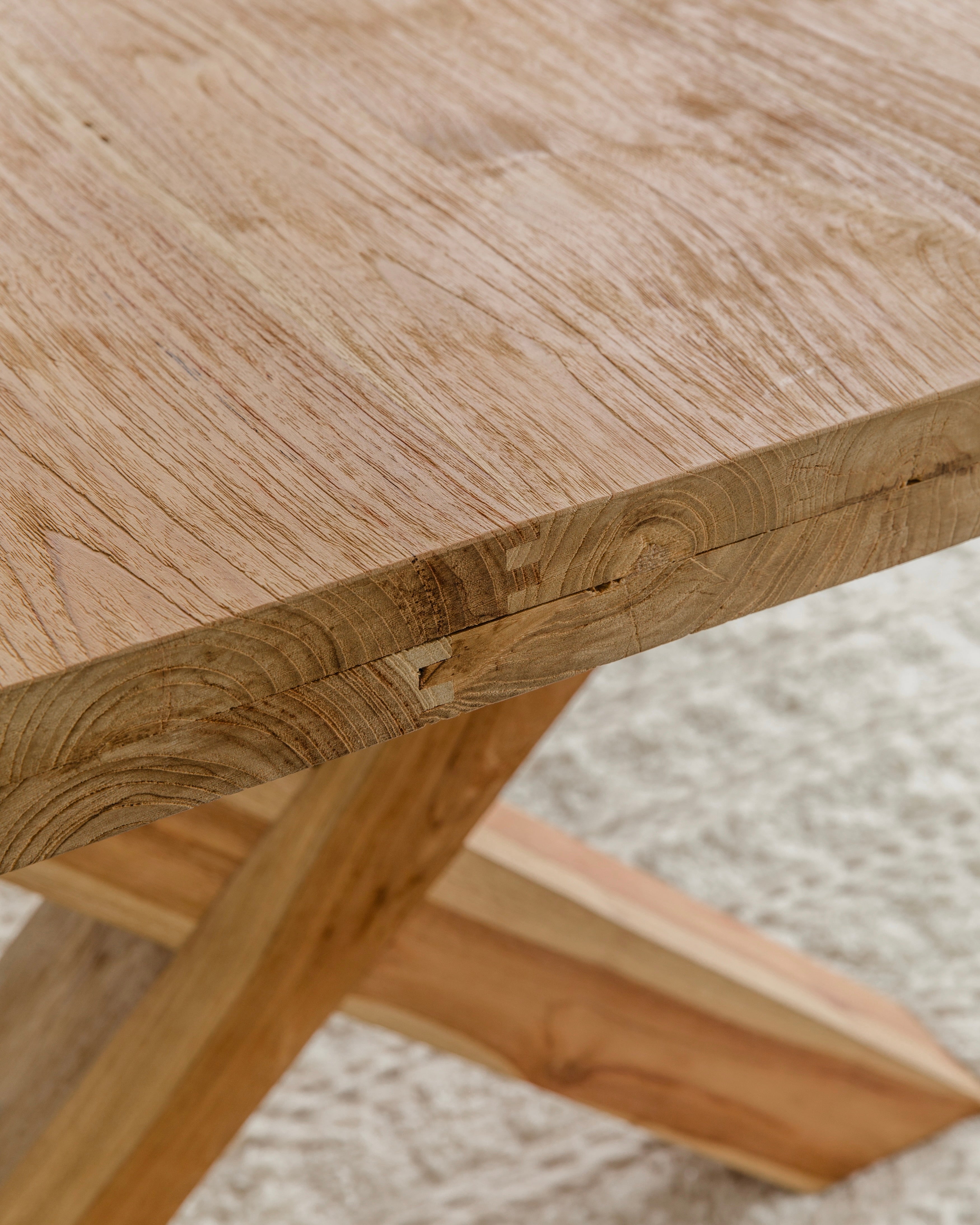 close up view of wood grain for solid teak wood dining table with cross legs