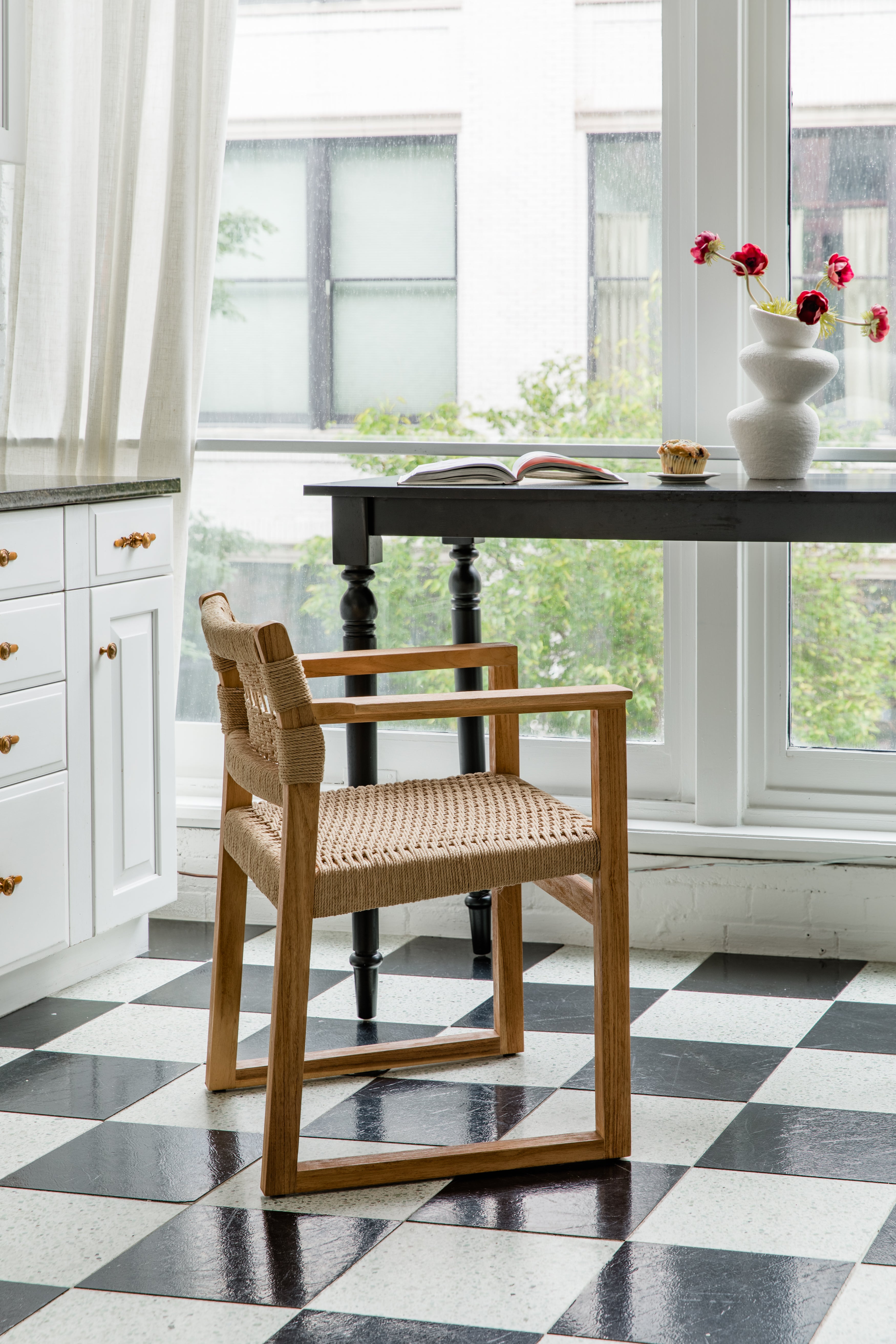 Paris-inspired kitchen nook with a natural wooden and textural arm chair