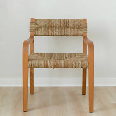 Natural wooden dining chair with curved arms and a woven seagrass back and seat