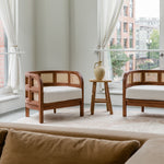 Living room scene with a pair of wooden walnut caned accent chairs with a natural sustainable vibe