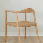 angular back view of a natural light wooden chair with a jute rope woven seat that's sustainable
