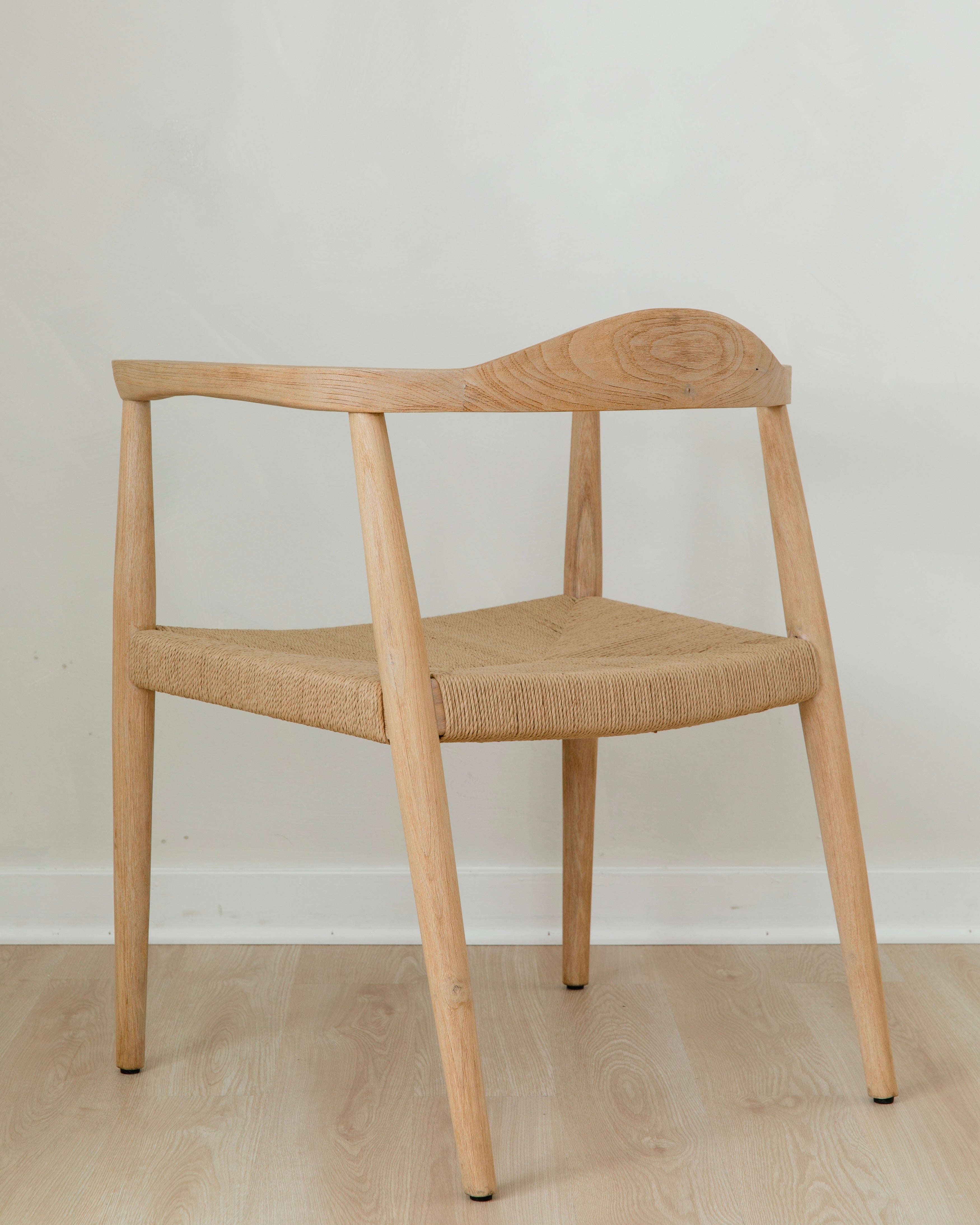 angular back view of a natural light wooden chair with a jute rope woven seat that's sustainable