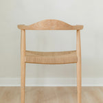 back view of a natural light wooden chair with a jute rope woven seat that's sustainable