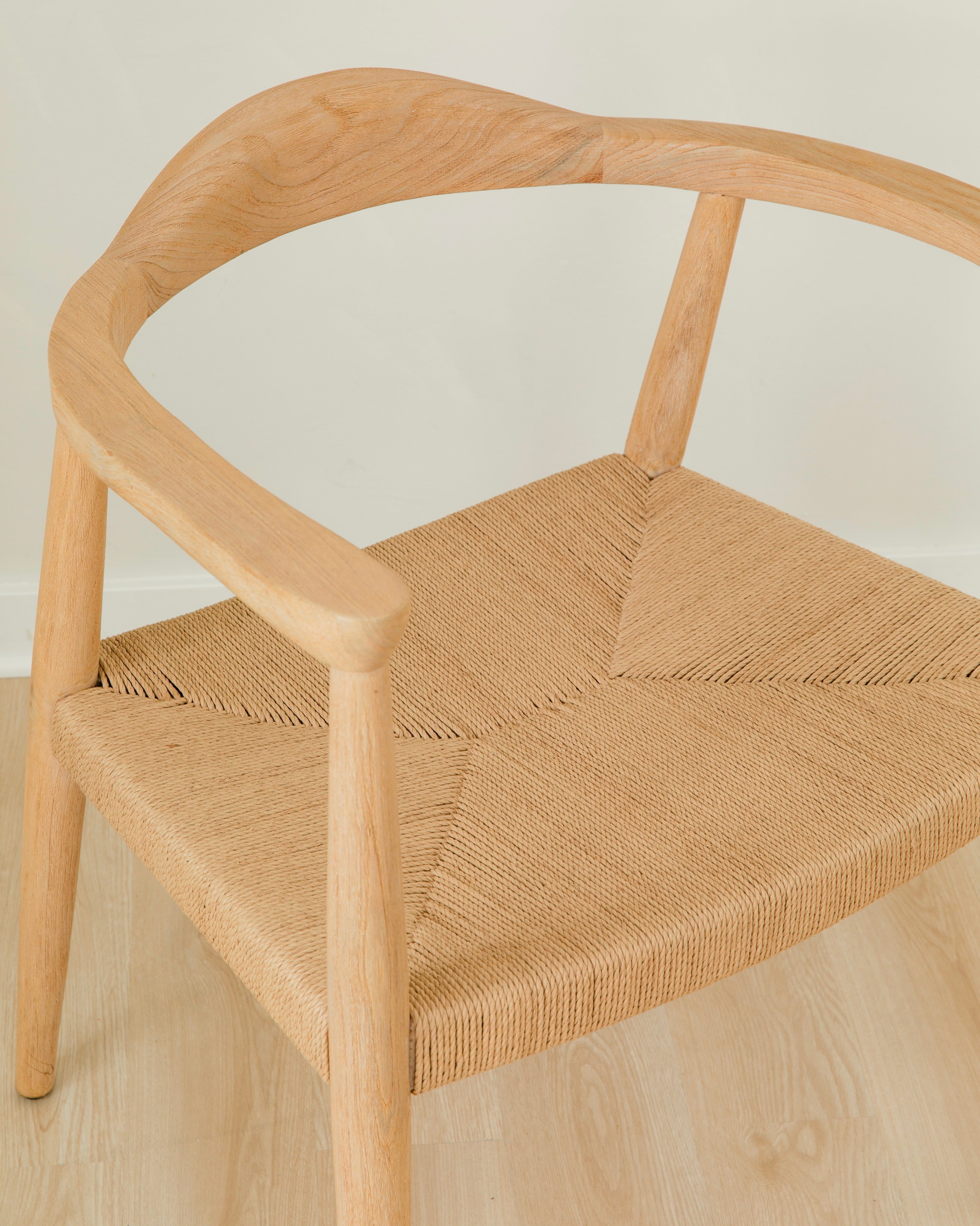 close up view of a natural light wooden chair with a jute rope woven seat that's sustainable