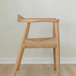 side view of a natural light wooden chair with a jute rope woven seat