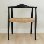 modern matte black dining room chair with a curved back and a jute rope woven seat
