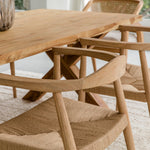 close up view of a dining room setting with natural wooden dining room tables and chairs with woven seats