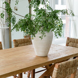 sustainable solid wood dining table and seagrass chairs in a dining room light and bright setting