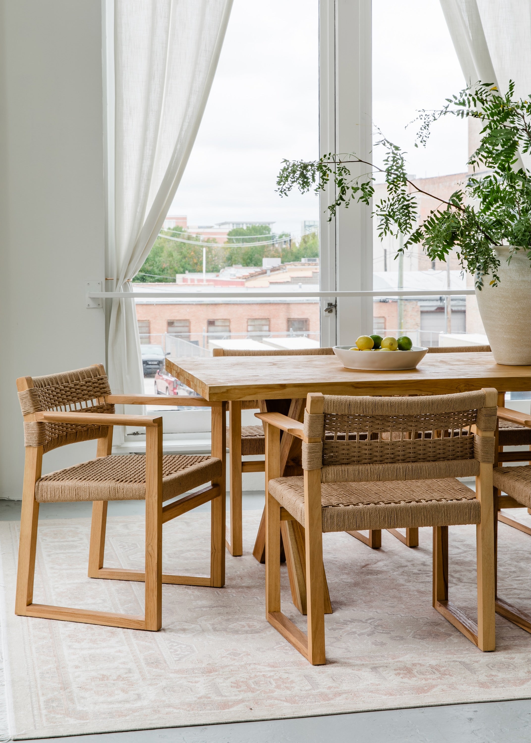 Natural solid wood dining table and chairs in a light and airy aesthetic