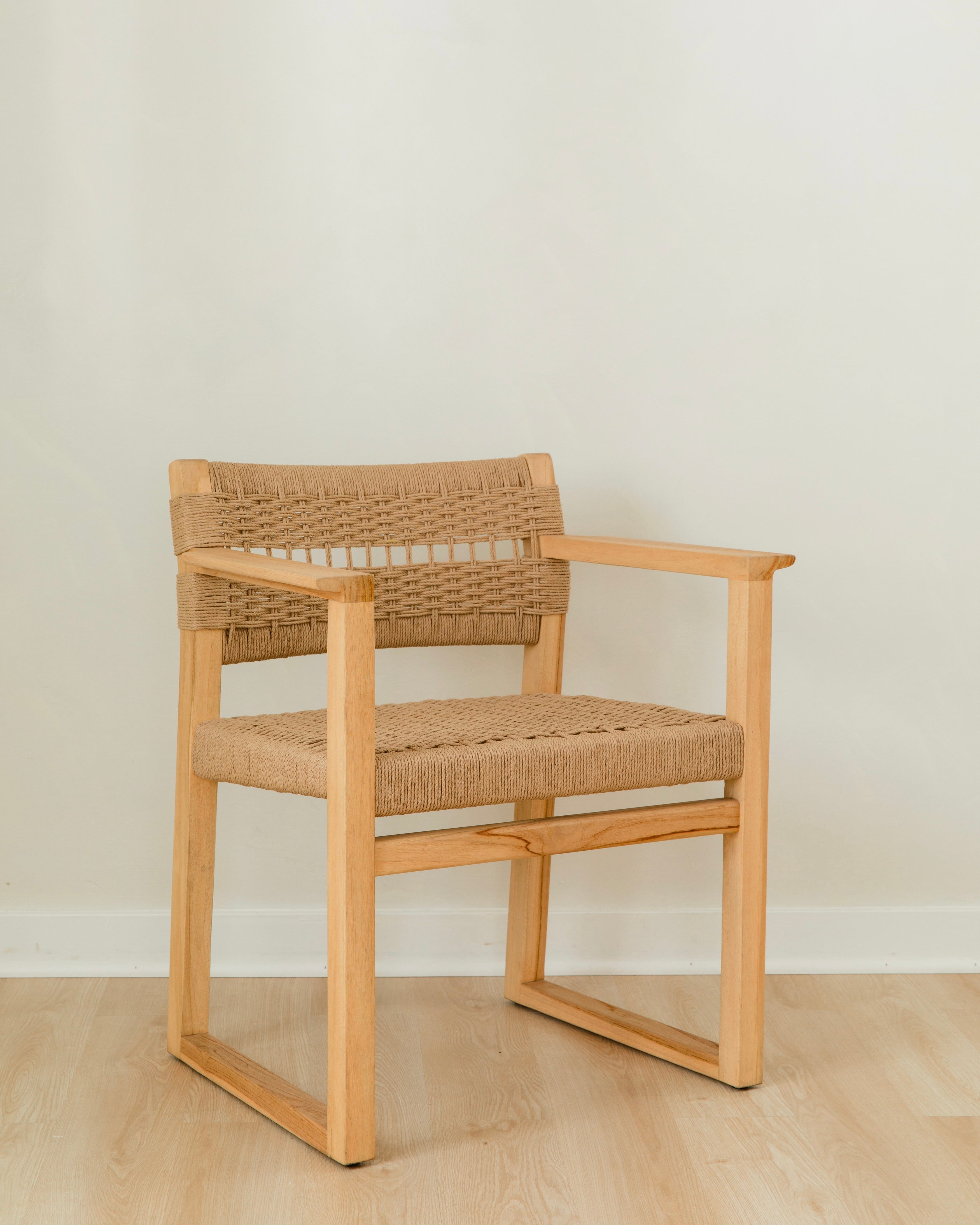 angular view of a sustainable wooden dining chair with arms and a woven jute rope seat and back