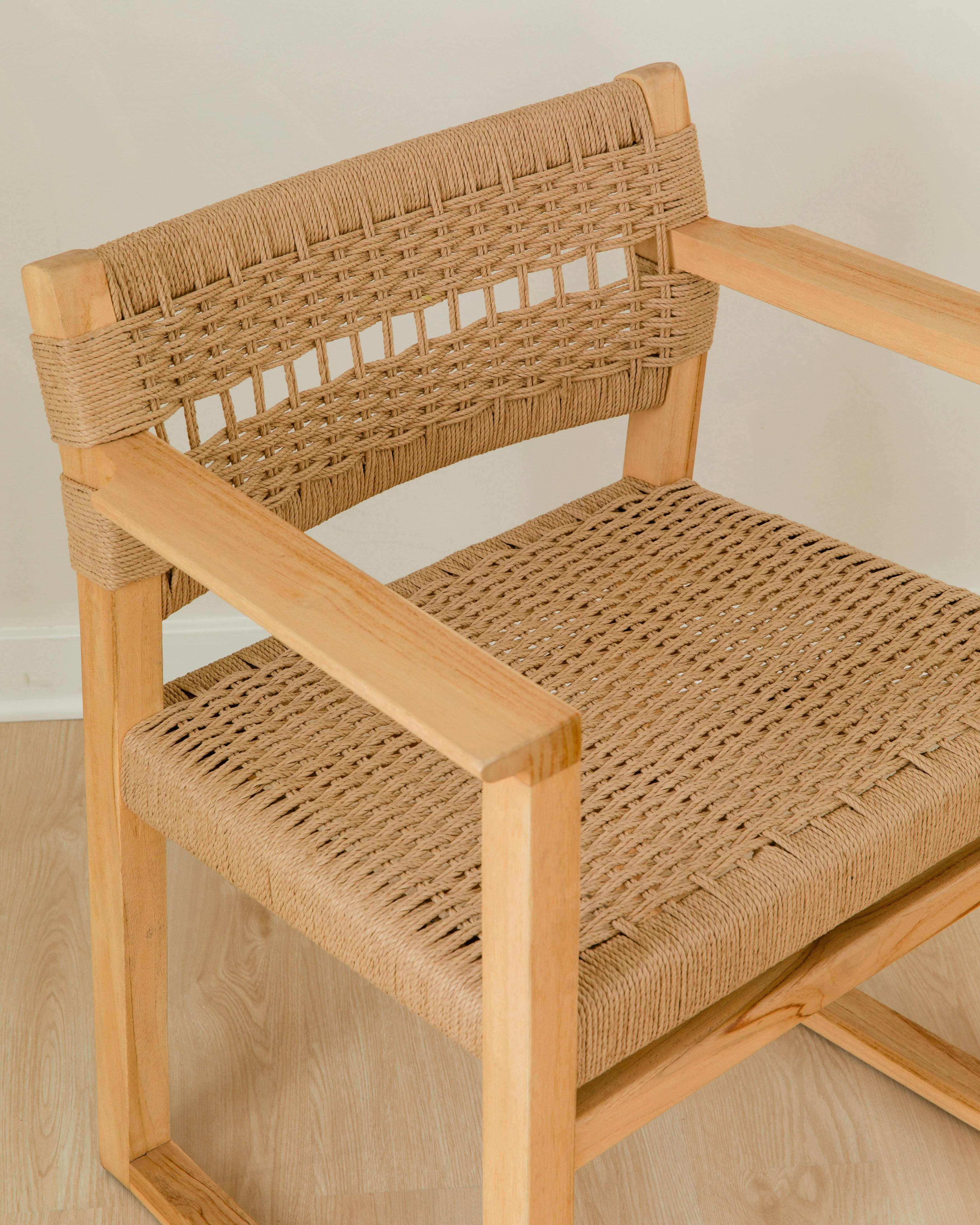 close up view of the jute rope woven seat and back of a wooden dining chair with arms
