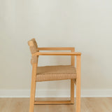 side view of a natural wooden dining chair with arms and a woven jute rope seat and back