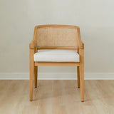 curved and caned accent chair in a natural solid teak wood with a white cushion seat