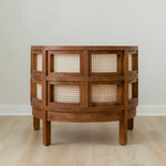 back view of curved and caned accent chair in a club style with a walnut wooden stain finish and white cushion