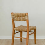 angular back view of classic wooden chair in a honey stain with a woven seagrass back and seat
