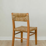 angular back view of classic wooden chair in a honey stain with a woven seagrass back and seat