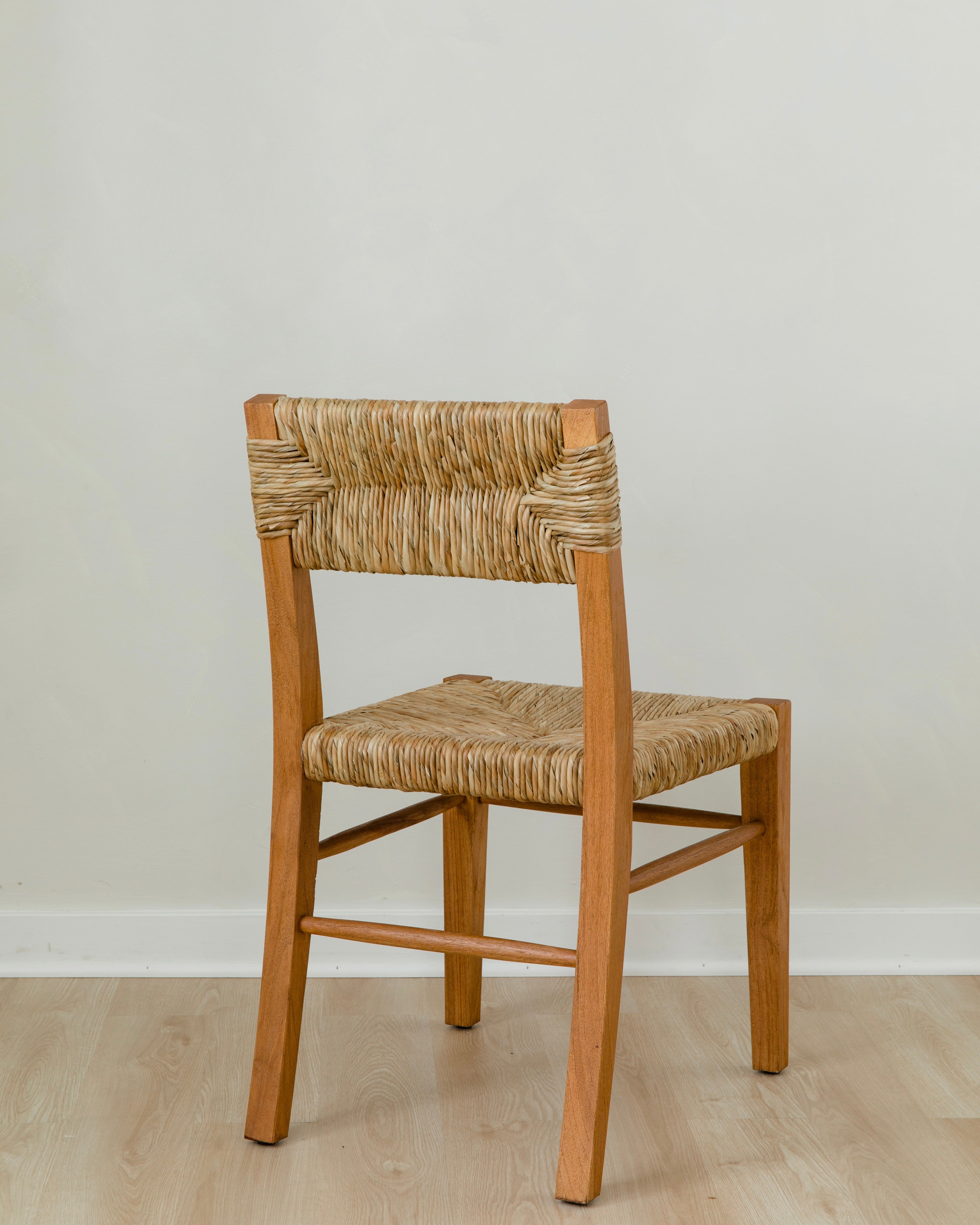 angular back view of classic wooden chair in a honey stain with a woven seagrass back and seat