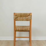 back view of a boho wooden chair in a honey stain with a woven seagrass back and seat