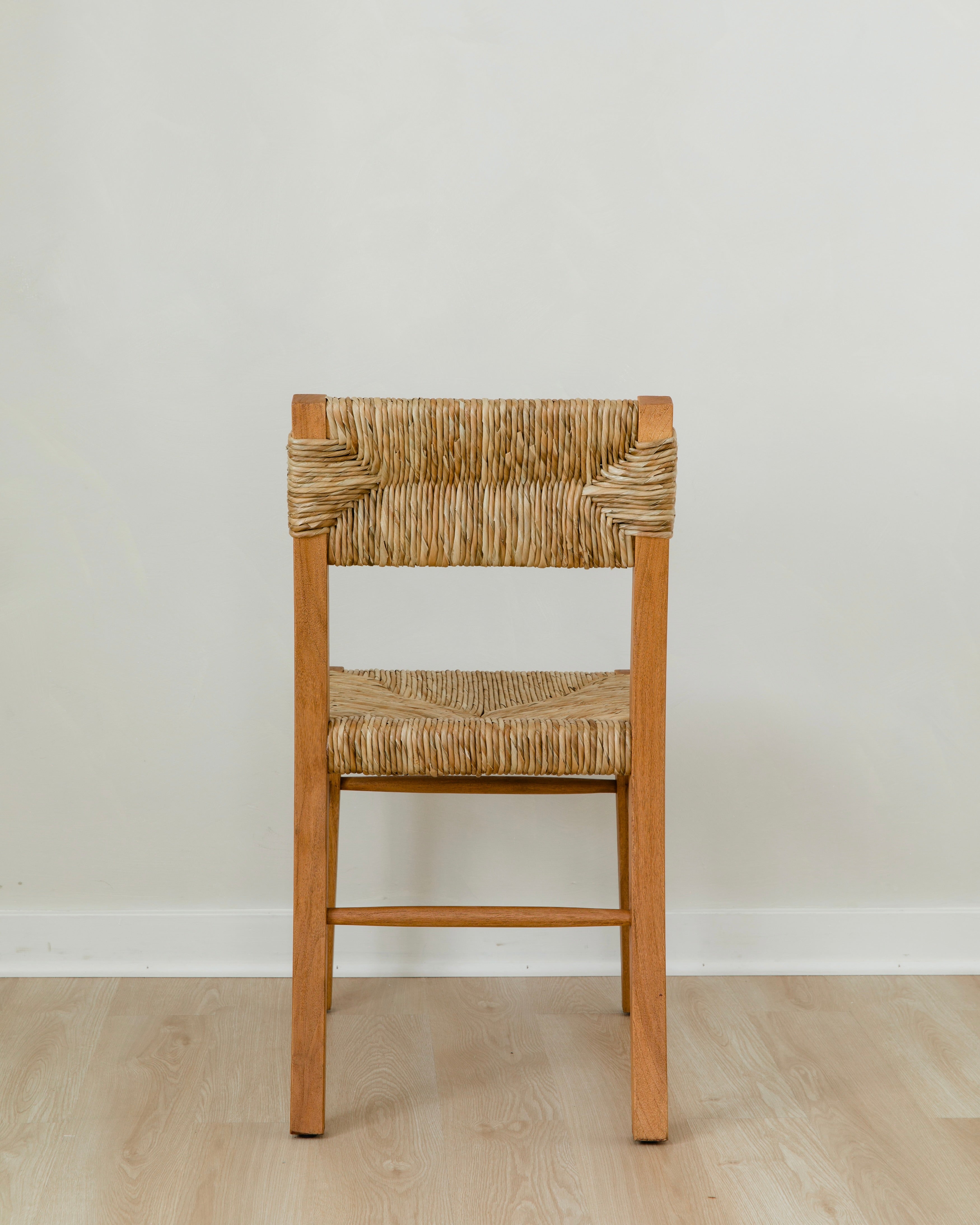 back view of a boho wooden chair in a honey stain with a woven seagrass back and seat