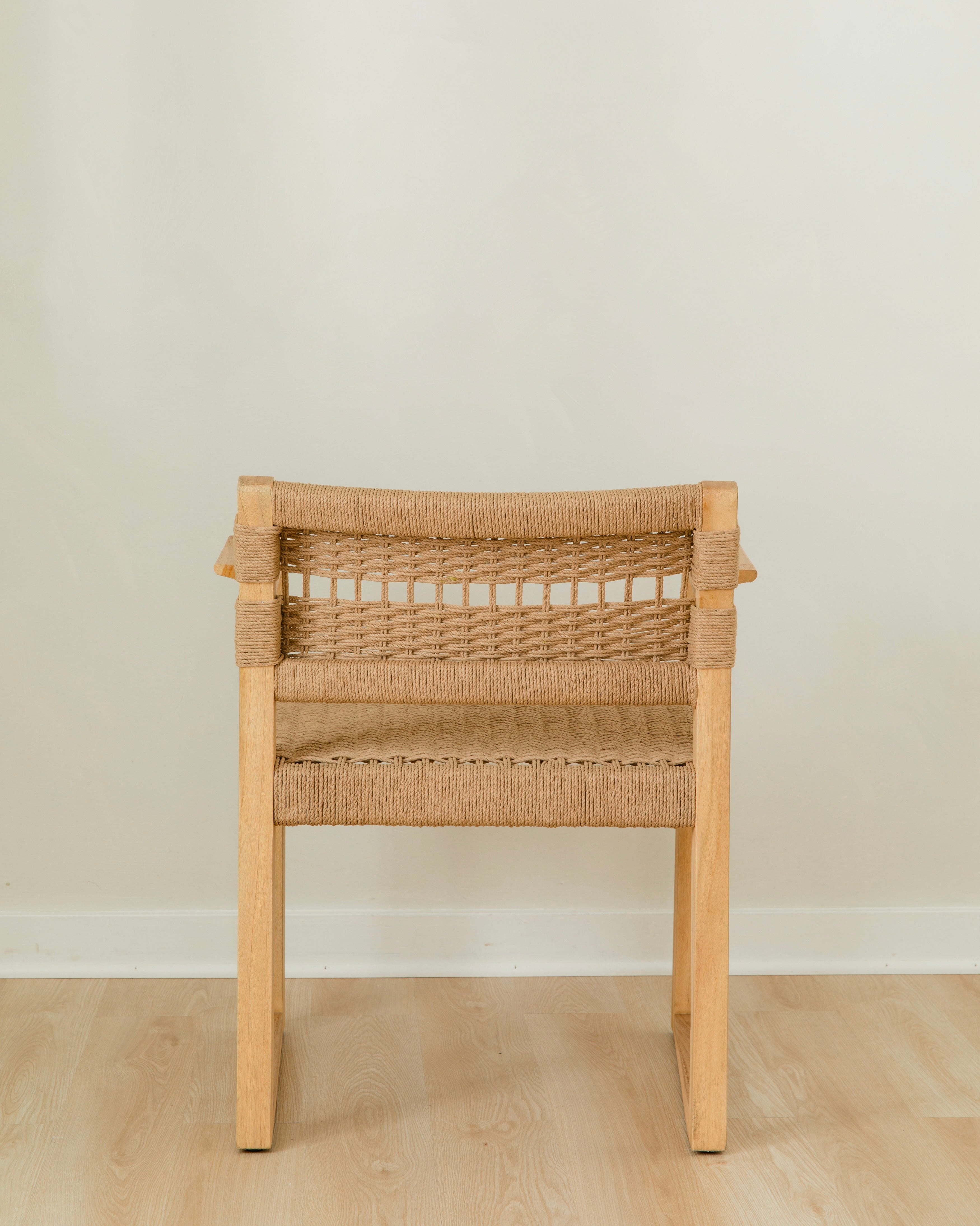back view of a sustainable wooden dining chair with arms and a woven jute rope seat and back
