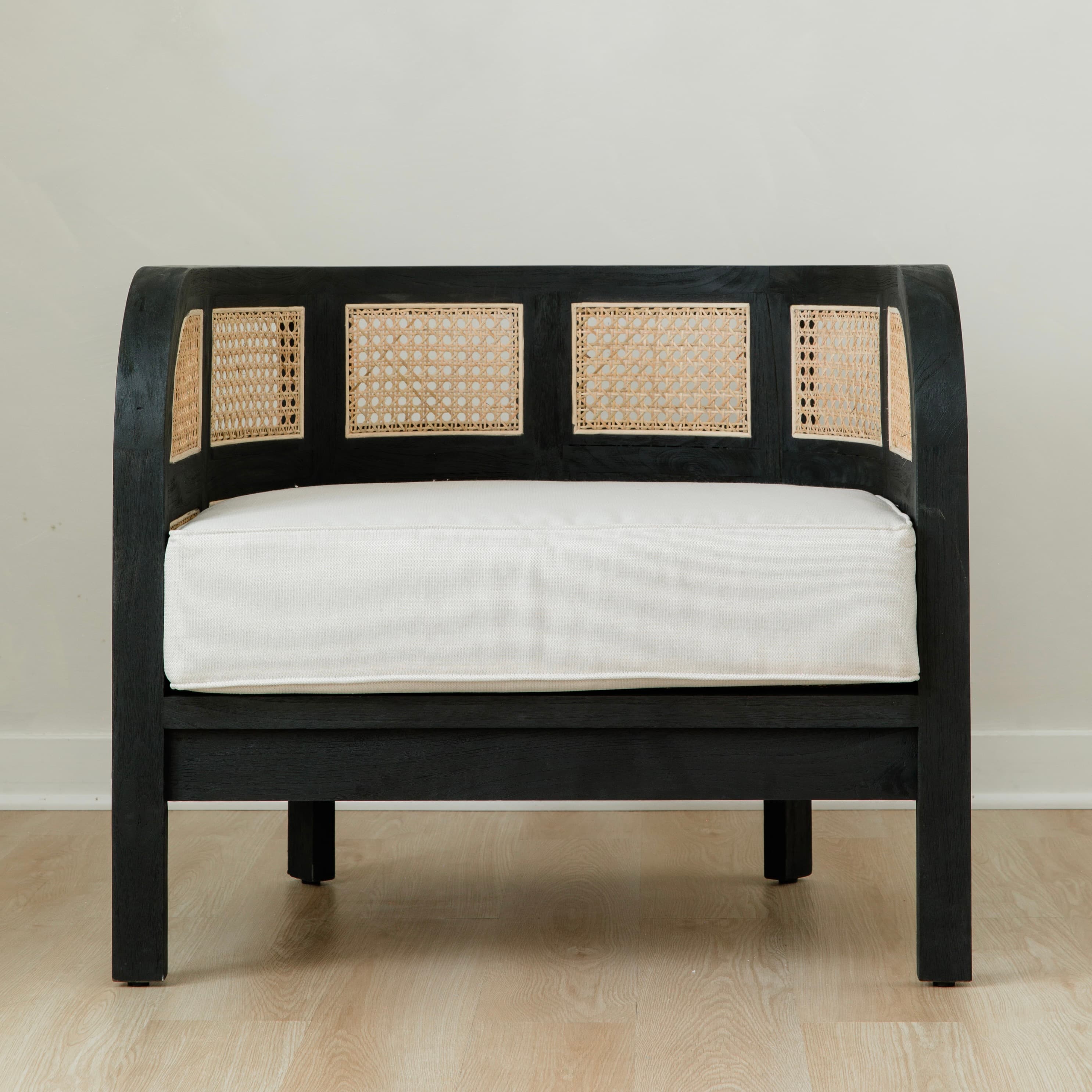black and white caned club chair with retro vibes and a curved back
