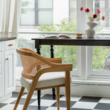 Parisian style kitchen with a checkerboard floor and a natural wooden caned curved back chair