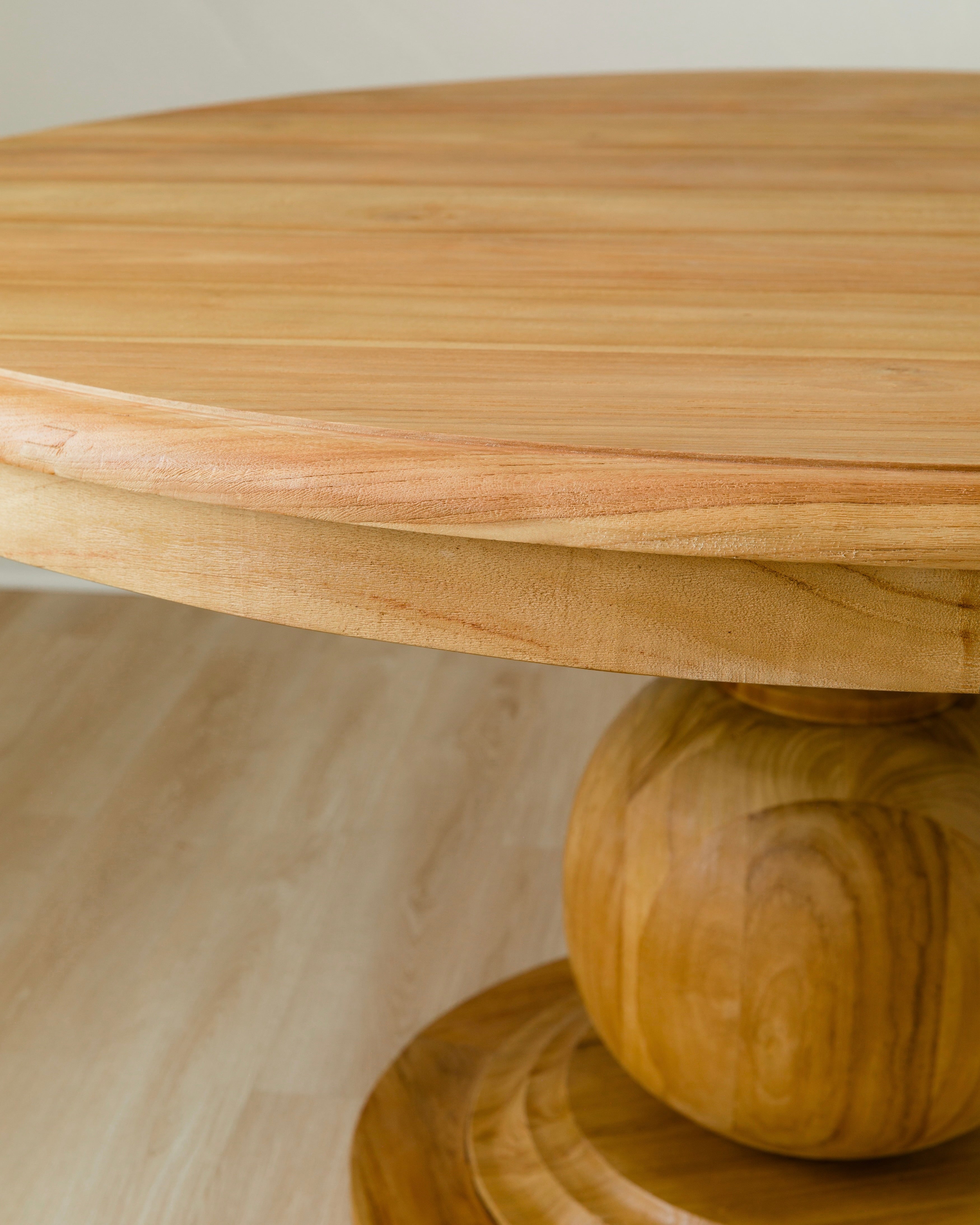 close up of wood grain for round dining table with a round ball pedestal base in mango wood