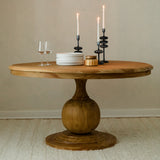 round mango wood dining table with natural finish in a cozy dining room with candles