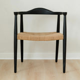 modern matte black dining room chair with a curved back and a jute rope woven seat