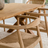 close up view of a dining room setting with natural wooden dining room tables and chairs with woven seats