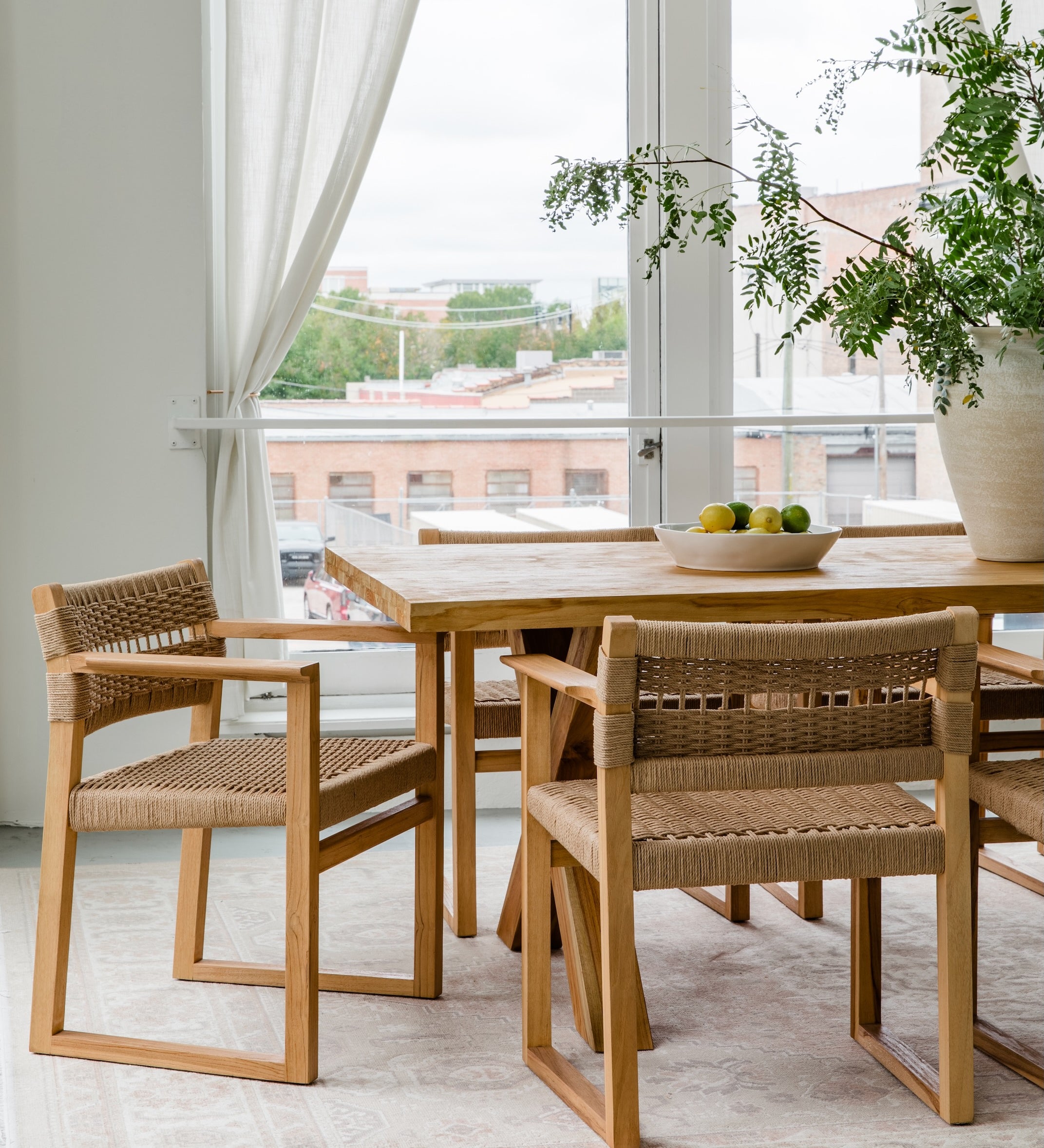 Natural solid wood dining table and chairs in a light and airy aesthetic