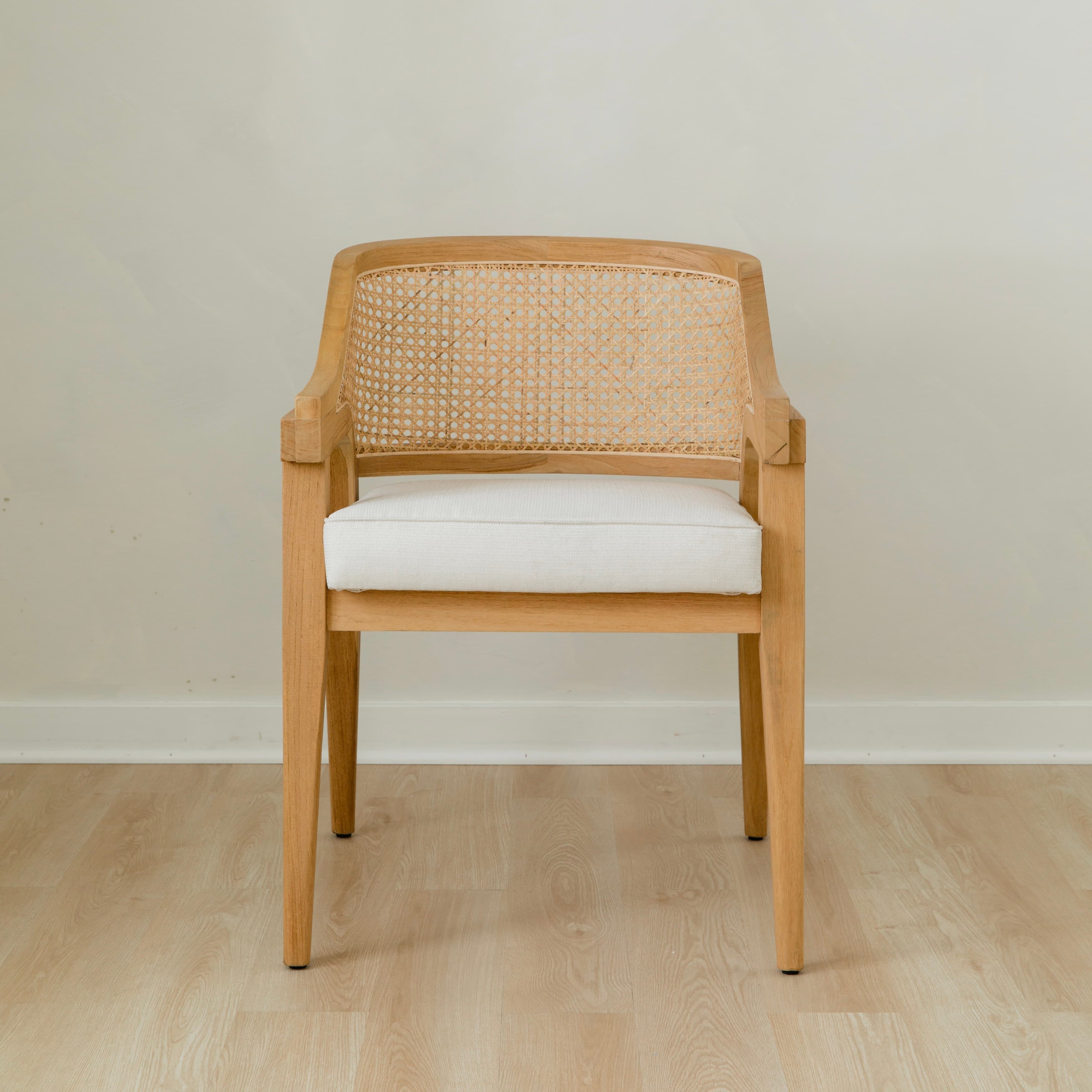 curved and caned accent chair in a natural solid teak wood with a white cushion seat