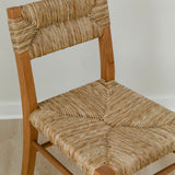 close up view of an artisan wooden chair in a honey stain with a woven seagrass back and seat
