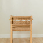 back view of a sustainable wooden dining chair with arms and a woven jute rope seat and back